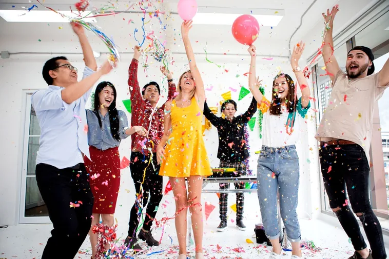 Collega's vieren een jubileum met confetti en ballonnen