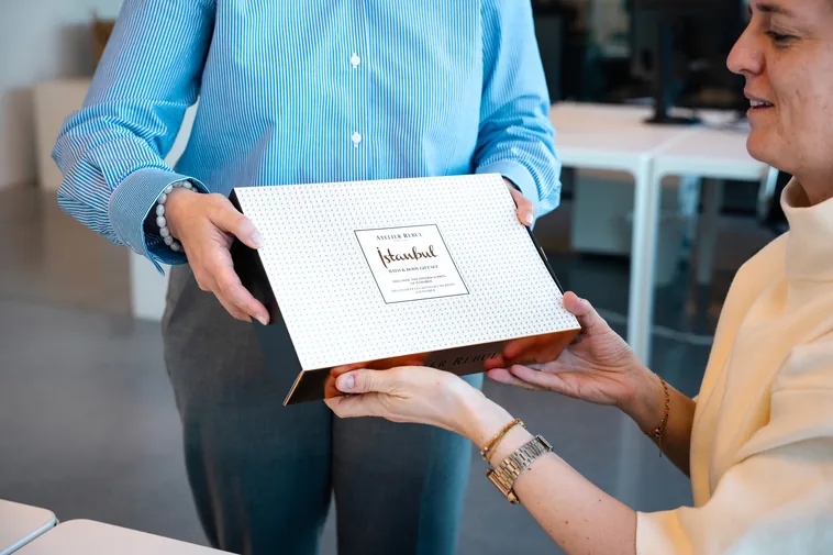 Collega overhandigt een geschenkdoos op kantoor